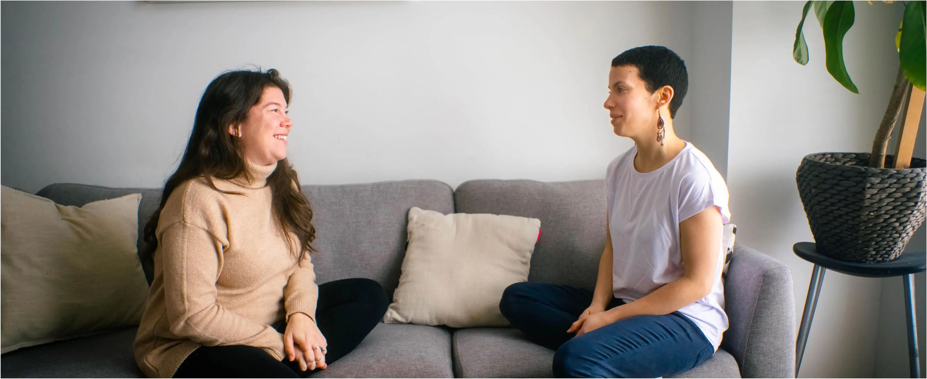Une doula et une cliente discutent, assises sur un canapé